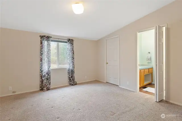 The primary bedroom looks out toward the garden areas and studio. It offers ample closet space and of course, a private bath.