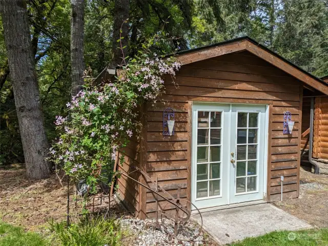 Here is the storage outbuilding which contains the well head. The French doors open, and a riding lawnmower will easily fit inside. The Clematis is gorgeous much of the year!