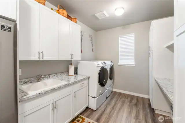 Now, this is GREAT laundry/mud room that has an abundance of cupboards, countertop space, a sink & an extra fridge/freezer!