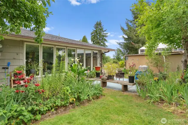 Patio space in side yard. Lots of beautiful flowers and perennials.