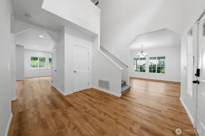Entrance from front door showing stairs to upstairs, formal dining room on far right and family room entrance on left