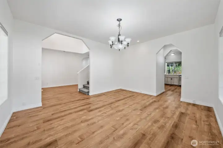Formal dining looking into kitchen on far right, front hall and stairs to upstairs on left