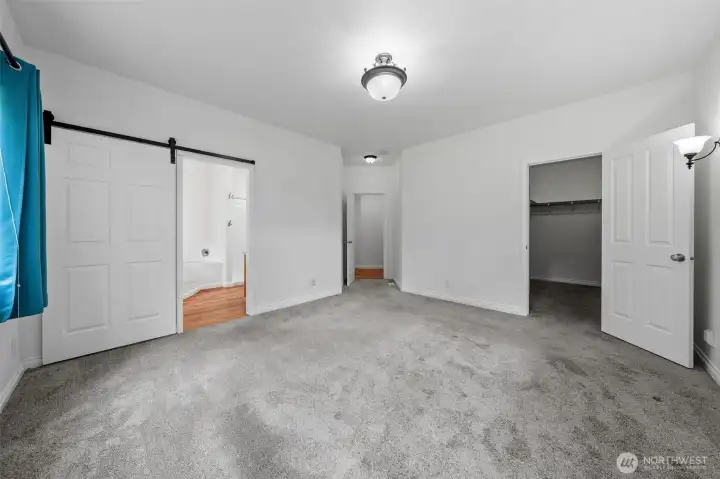 Primary bedroom, closet on right with bathroom on left