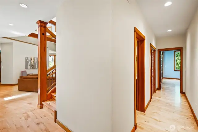 Hallway to the primary bedroom, half bath, & laundry room