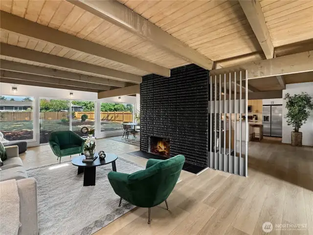 The bold dual sided fireplace is a captivating focal point for the main living spaces of the house