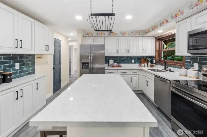 The kitchen has been beautifully updated in 2024 with new cabinets, sleek stone counters, and a striking tile backsplash. A spacious center island with outlets offers both function and style, making this the heart of the home.