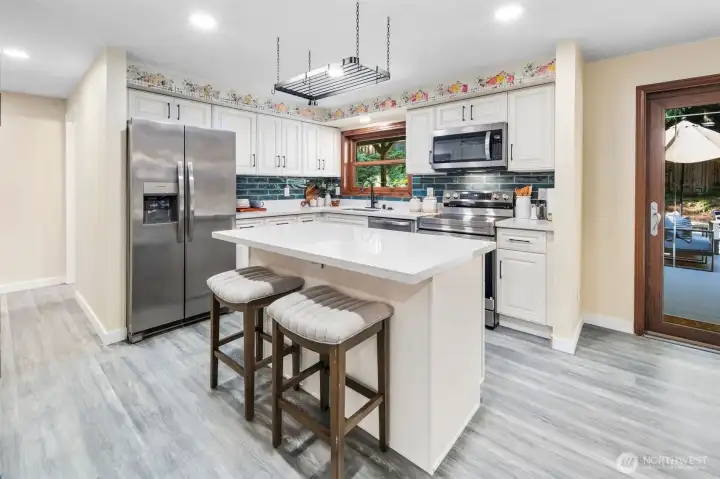 A stylish overhead pot rack adds both function and charm to the kitchen. The new 2024 stainless steel refrigerator features an ice and water dispenser, complete with new water and air filters for freshness and convenience.