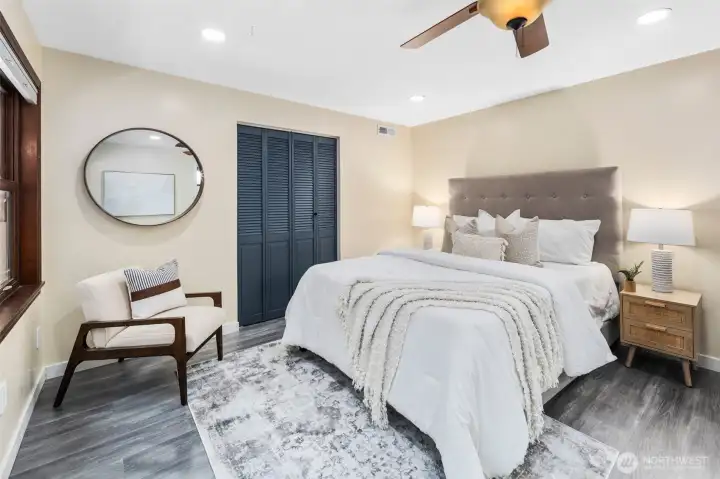 The primary bedroom offers impressive space, easily accommodating a king-size bed along with a large dresser. A folding-door closet painted in the home’s signature slate blue adds both function and style, continuing the home’s cohesive design.