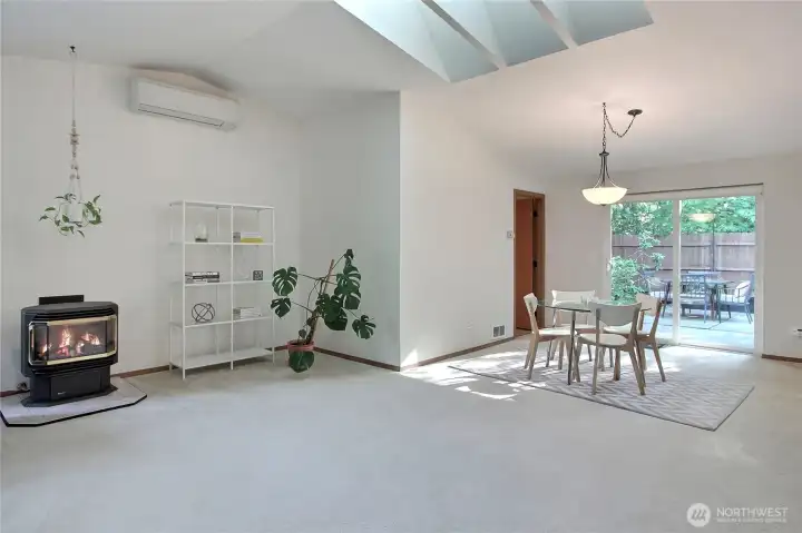 View from the Great Room to your Dining Room, love the gas stove, skylights, vaulted ceilings and patio doors leading to your patio and fenced-in yard. Newer mini-split to keep you comfortable year-round, and door off dining leads to your utility room and attached garage.