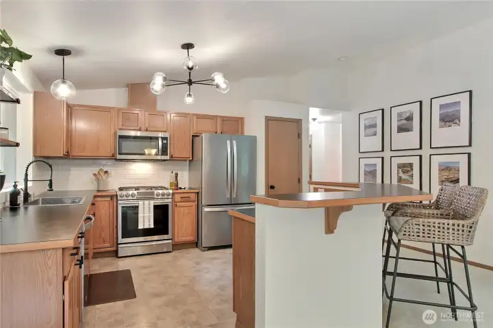 Kitchen view one, love the breakfast bar/island and all the counter space. I also love the light fixture choices and all appliances are included.