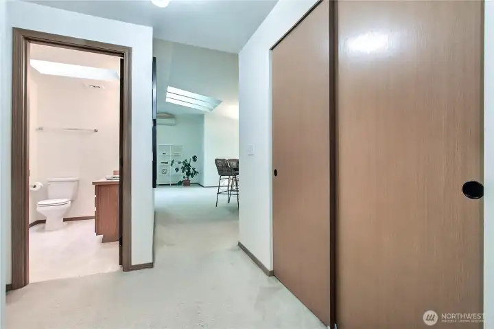 Hallway view to kitchen and dining from beds and baths, large linen closet to your right, full kids/guest bath to your left.