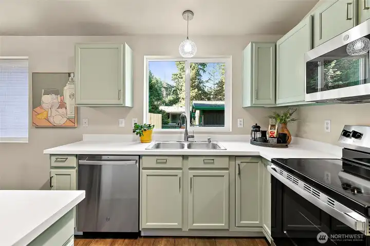 Freshly painted in a timeless, soft green, the kitchen cabinets bring warmth and charm to the space, accented by stylish new hardware that completes the fresh, updated look.