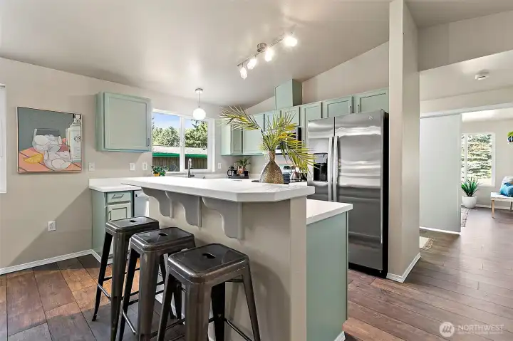 At the heart of the open kitchen, the island with its welcoming breakfast bar invites everyone to gather, whether for a quick bite, conversation, or a cozy start to the day.
