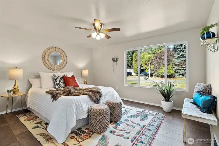 Unwind in the spacious primary bedroom, complete with a ceiling fan for comfort and fresh new lighting that adds a soft, welcoming glow.