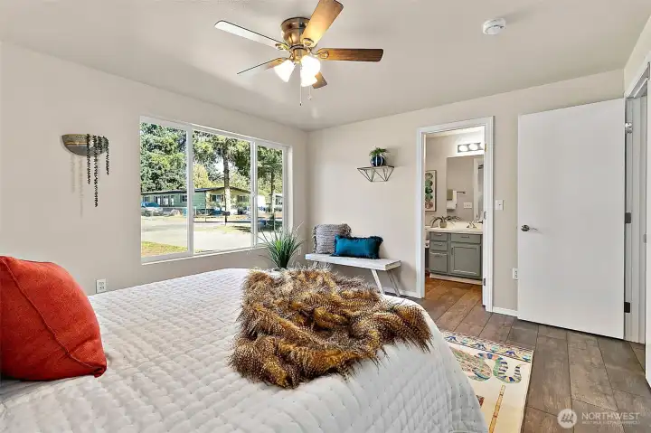 The large primary bedroom features a ceiling fan and updated lighting, creating a bright and comfortable space to relax and recharge.