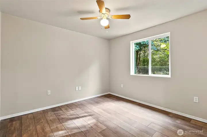 One of the three bedrooms.  Beautiful new LVP flooring runs throughout the home, offering the perfect blend of style, durability, and easy maintenance while tying every room together with a warm, cohesive look.