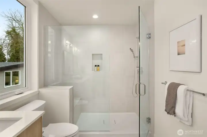 Large glass-enclosed walk-in shower with high-end finishes for a luxurious daily experience