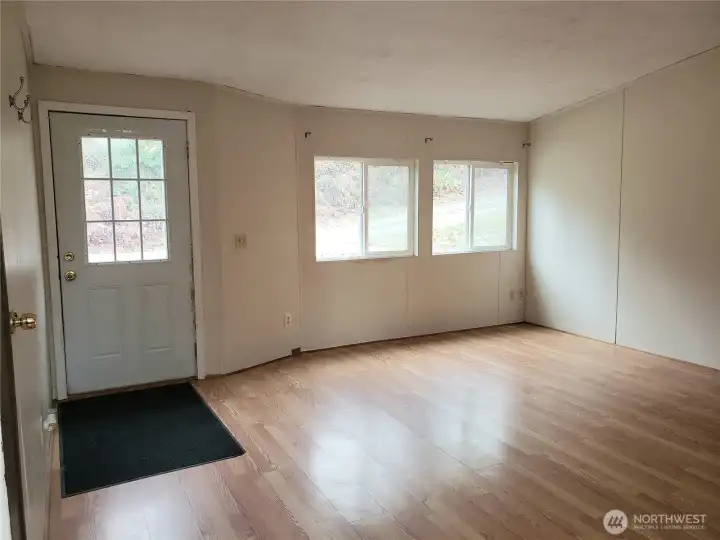A Different View of the Huge Living Room Showing Laminate Flooring Looking at the Front Entry Door.