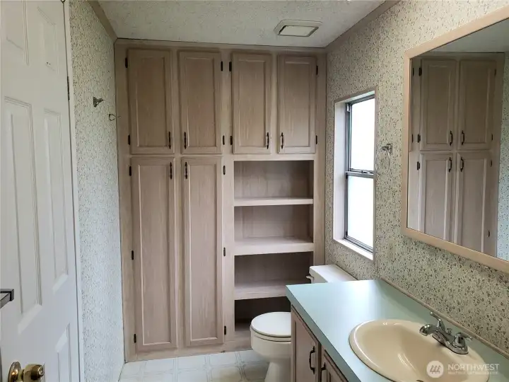 Primary Bathroom Showing Full Shower Unit, Large Vanity and Full Wall Storage Area Linen Closet.