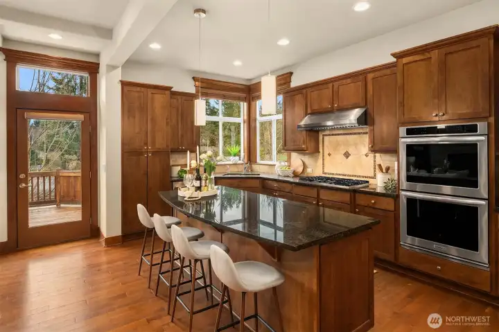 The chef's kitchen is an entertainer's dream, featuring an expansive island, double ovens & stainless appliances for an inviting heart of the home.