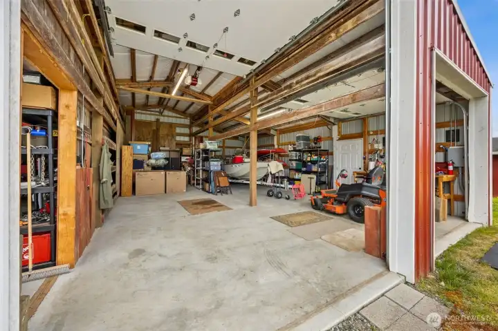 The two additional bays come into view here, including that impressive 13-foot center bay that opens the door to storing or working on larger equipment, boats, RVs, or whatever oversized project has been waiting for the right space. Flanking 9-foot bays add even more flexibility. And then there is a detail people always appreciate in real life, the man door off to the right, so you can step into the building without rolling up one of those big doors every time.