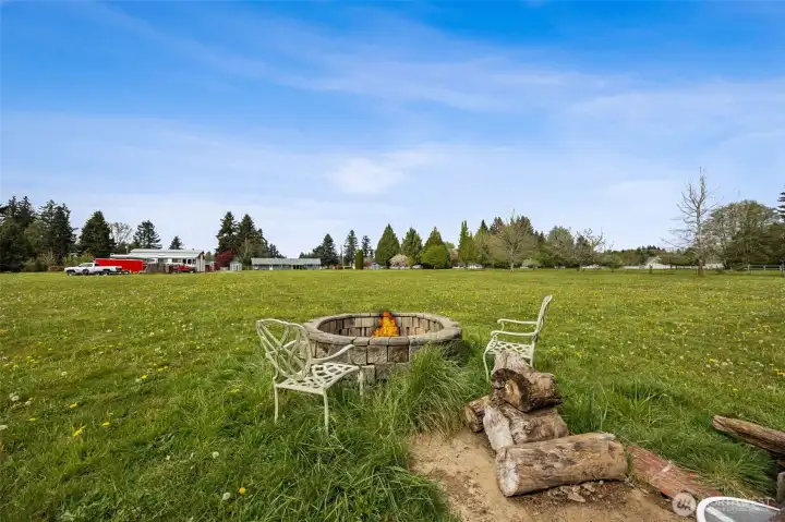 Set toward the back of the acreage, the fire pit creates a natural gathering place, the kind people drift toward without being invited twice. Looking back toward the home from here, you get that wonderful sense of space and connection all at once. The burn pile already started is practical, but it also hints at a property that has been actively enjoyed. And can we talk about roasting marshmallows under open skies like this? That is memory-making territory. Storytelling, laughter, kids running until dusk, friends lingering longer than planned, this has all the ingredients to become the place everyone wants to end up when they need to relax and reconnect.