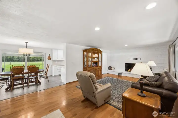 From the front door, your sightline runs straight through the dining area and out the sliding glass doors to acres of open pasture beyond, and that is a pretty fabulous first impression. The generous tile entry is a smart touch too, protecting those beautiful oak hardwoods where traffic hits hardest while giving the space a grounded, welcoming start. And then there’s the floor plan, quietly doing something very right, as you can move toward the dining room and kitchen one way, or circle around near the fireplace the other, creating that easy loop flow that makes everyday living feel organized and gatherings move naturally. This extra doorway was an addition made during the recent kitchen remodel.