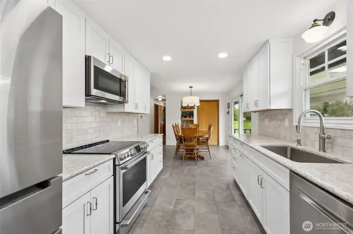 There is a reason professional kitchens lean into this kind of galley-style efficient working arrangement, because everything is within reach, movement feels natural, and cooking becomes easier, faster and honestly more enjoyable. Here, that smart layout gets elevated with matching Café microwave and electric cooktop, Bosch refrigerator, and a finish palette that feels clean and cohesive. Looking toward the dining room, you can feel how connected the spaces are, so the cook never disappears from the conversation.