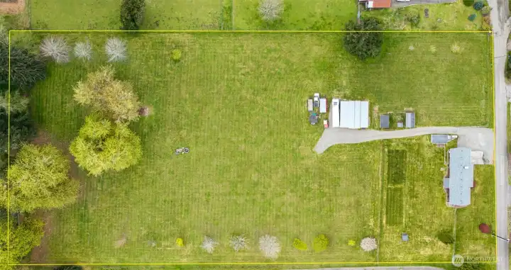 With approximate lot lines outlined, you can see the balance right away, open acreage, home placement, and outbuildings positioned close enough for convenience but with enough separation that the activity stays where it belongs.The shop and supporting structures are accessible without feeling like they crowd the house. There’s a newer gravel driveway and expanded parking too, which adds a whole other layer of practicality, making maneuvering easier for trailers, equipment, daily use, or the kind of big gatherings this property was made for. Family comes over, guests spill out, trucks park, people linger, and there is room for all of it.