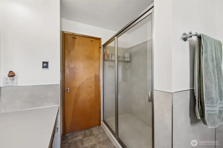Here you get a better look at that generous double-wide walk-in shower, and it really reinforces how functional this bath is. There is room to move, room to breathe, and a simplicity to the layout that just works. But some of the best features tied to this property are not only what you see, they are what has already been improved behind the walls and out on the land. A newer water heater adds peace of mind, while the individual well serving the house and lawn has been supported with new wiring, a 30-amp pressure tank and pump, plus a dedicated pump house in the backyard. Those are meaningful upgrades, the kind that say this property has been cared for in ways both visible and practical.