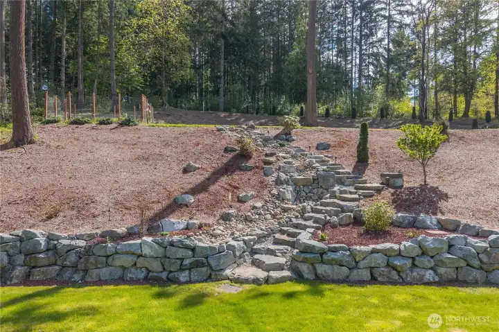 Waterfall that leads up to the upper property. Rock stairway leads along way to the upper garden area.