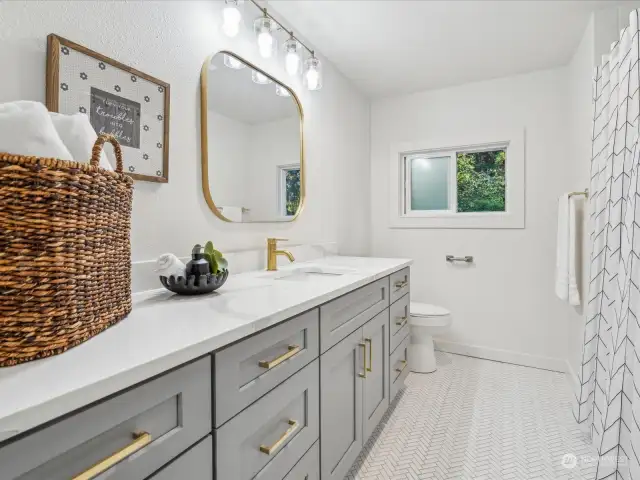 Hall full bath also a show stopper with gold finishes, quartz counters and herringbone tile