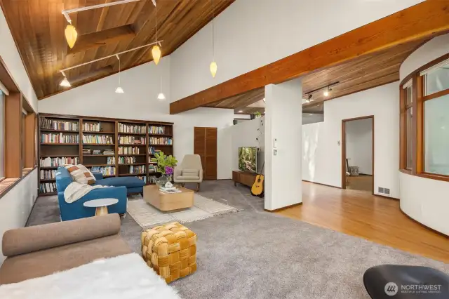 This spacious main floor family room offers cozy comfort with soaring ceilings, custom woodwork, and a wall of bookshelves perfect for relaxing or entertaining