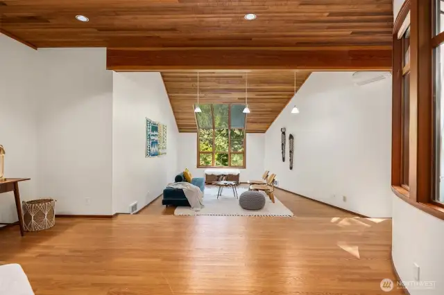 This expansive main floor office or bonus room features dramatic vaulted ceilings, a full curved wall of windows, and endless flexibility