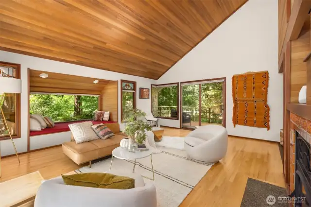 this glass & wood-surrounded lounging nook offers a serene retreat with views of the surrounding greenery.