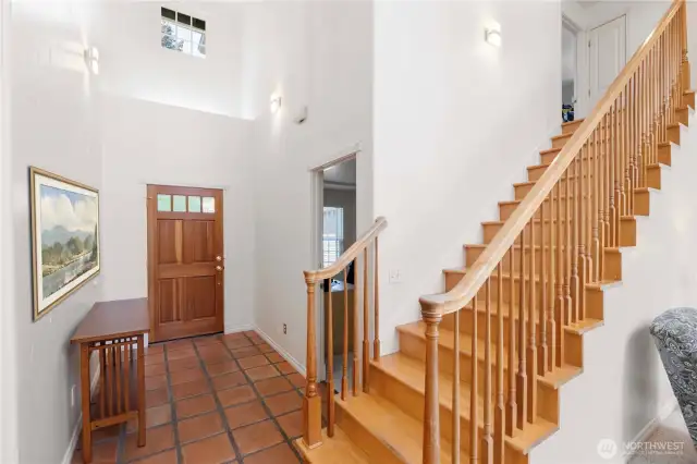 Upon entering, you'll find a conveniently located den or office just to the left of the entry—ideal for remote work or quiet study. A striking wooden staircase serves as the focal point, gracefully leading to the open landing above