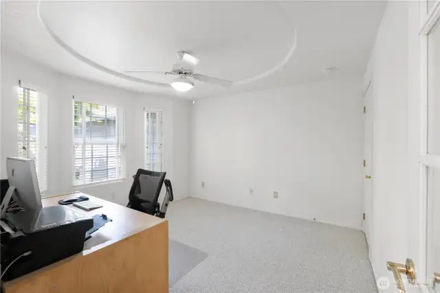 Working remotely? This spacious flex space is perfect as a home office, den, or creative studio. A contoured ceiling adds architectural interest, while large windows offer peaceful views of the front garden.