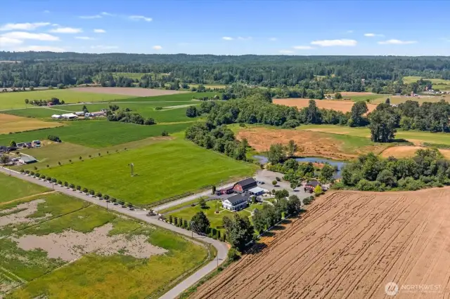 View of property looking west. Field with windmill and lake behind all part of the 30 acre estate