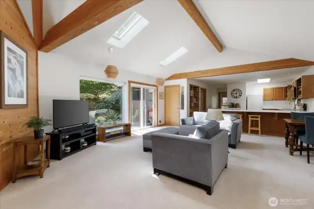 Great room styling with dining table on the right, an eating bar between the kitchen and living rooms.