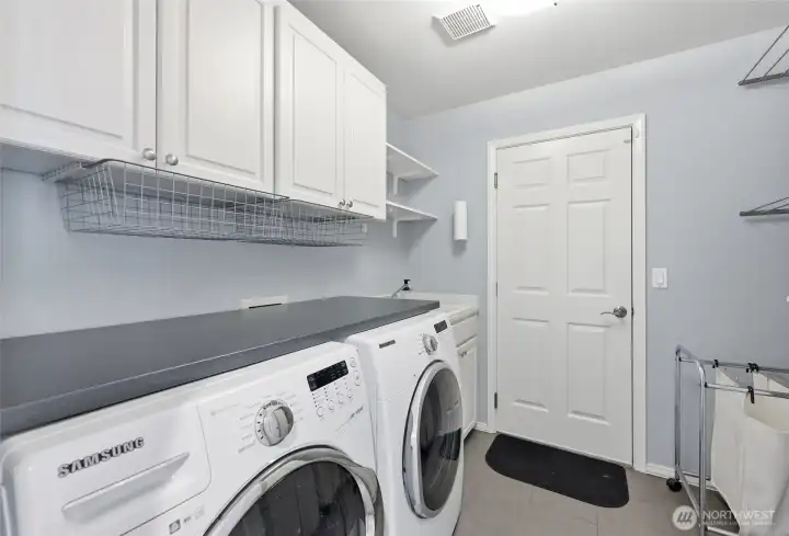 The laundry room and access to the garage (which has 3 bays, epoxy floors and an EV charger).