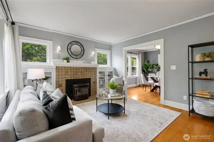 The spacious living room welcomes you with a cozy fireplace and abundant natural light