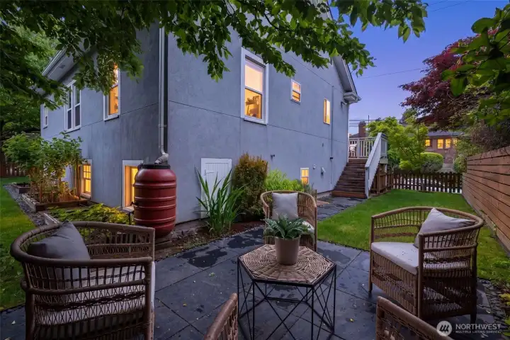 Outside, the property continues to impress with a thoughtfully designed yard featuring a grassy area, patio space, and raised garden beds