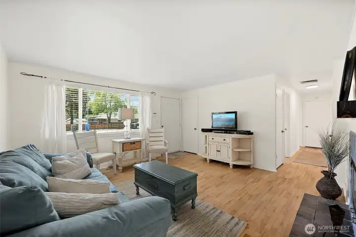 Living room with large front window and natural light. Living room with large front window and natural light.