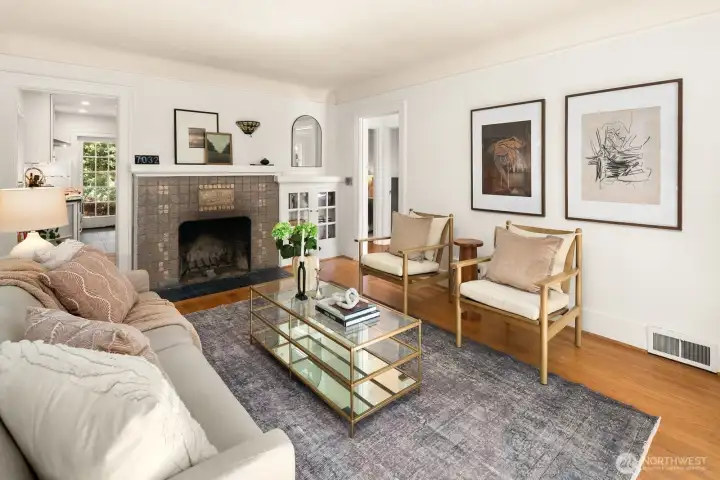 Bright living room with period details: original hardwoods, wood burning fireplace & coved ceilings