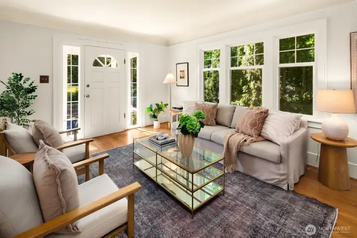 Bright living room with period details: original hardwoods, wood burning fireplace & coved ceilings