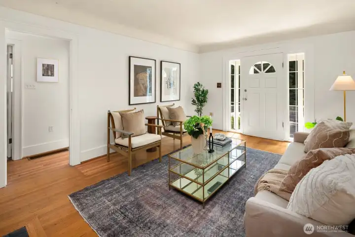 Bright living room with period details: original hardwoods, wood burning fireplace & coved ceilings