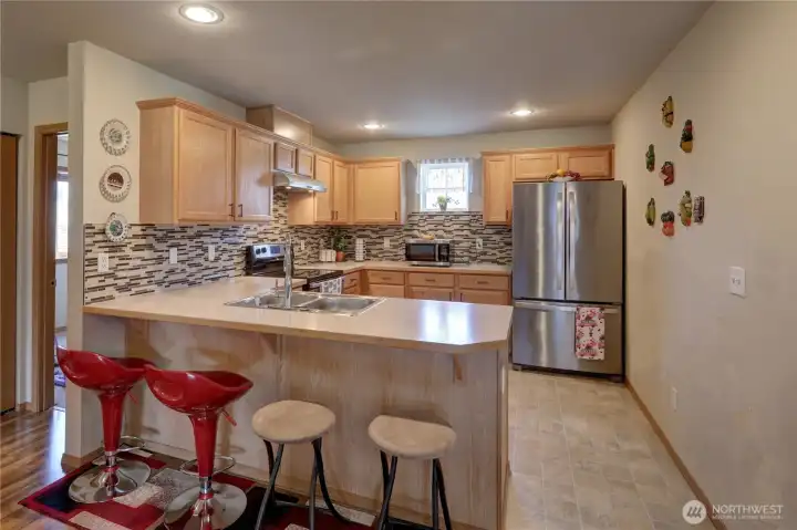 Bright, open kitchen with a convenient eating bar. Bright, open kitchen with a convenient eating bar.
