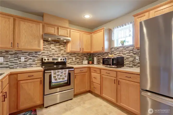 Spacious kitchen with abundant cabinetry, generous counter space, and stainless steel appliances. Spacious kitchen with abundant cabinetry, generous counter space, and stainless steel appliances.
