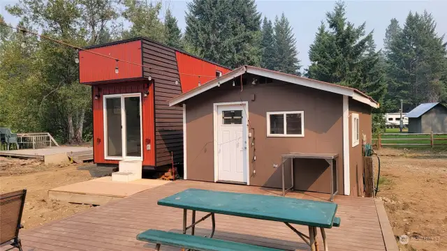The fronts of the tiny home and bunkhouse with the two decks.
