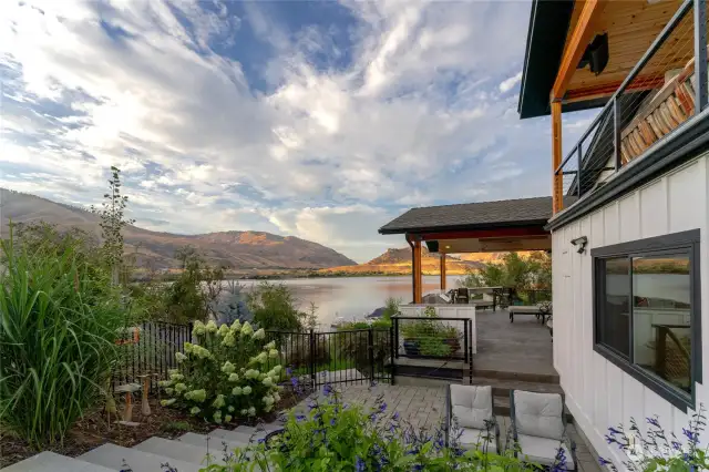 View of patio off of Main Level wraparound deck w/ outdoor kitchen, dining and lounge area.